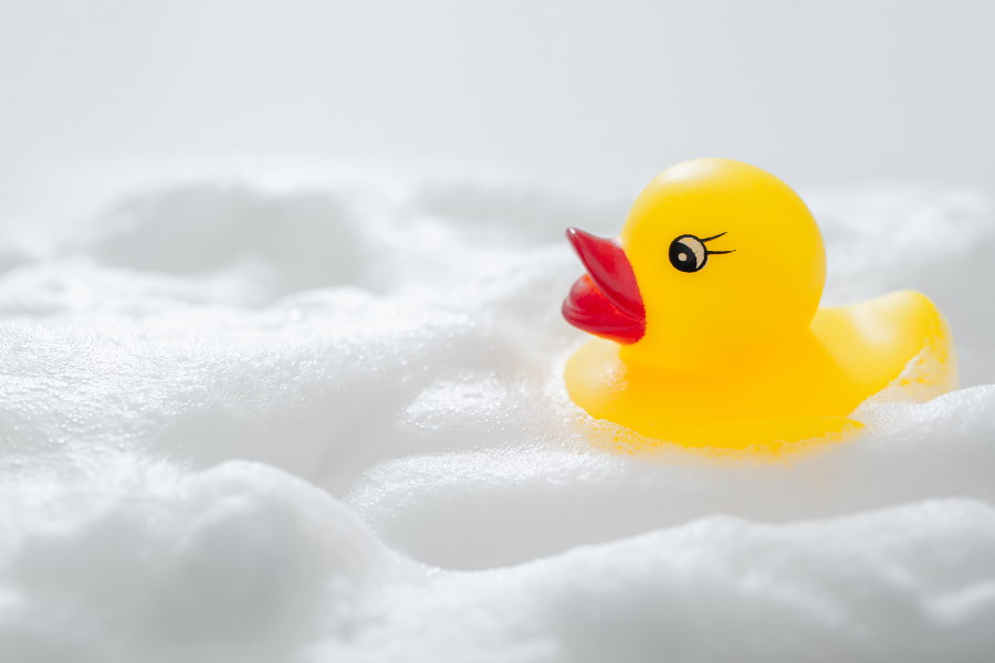 gumowa kaczka do kąpieli pływająca na pianie