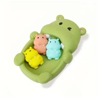 gumozwe zabawki do kąpieli dla niemowlaka - zielony hipcio z kolorowymi małymi hipciamy z gumy na białym tle
