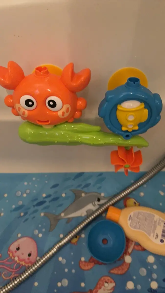 zabawka do kąpieli z pomarańczowym krabem przyczepiona nad wanną