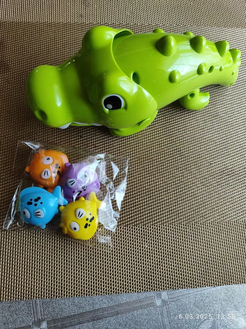 zabawka do wanny krokodyl oraz cztery kolorowe rybki na stole
